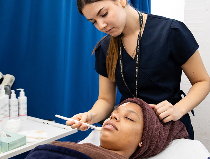 Student completing a facial on a client